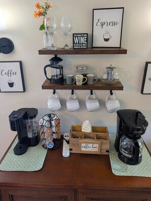 Ein Kaffeeangebot mit mehreren Kaffeemaschinen, Tassen und einem Schild für die Kaffeebar.