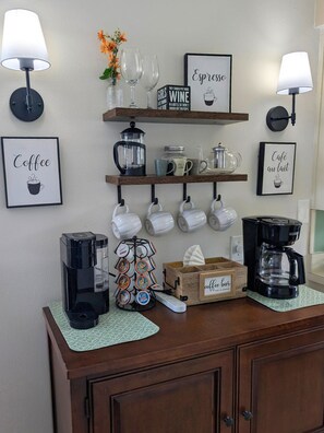 Eine Kaffeestation mit Kaffeemaschine, Tassenhalter und Kaffeekapseln.