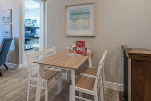 A room with a wooden table, white chairs, a framed picture on the wall, and a radiator. - Snow Canyon Poolhouse #65 + #66 (Santa Clara)