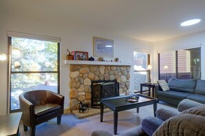 A living room with a stone fireplace, a leather chair, a sofa, and a coffee table. - Perfect Central Location - Walk to Base 9 Lifts (Breckenridge)