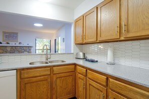 A kitchen with wooden cabinets, a stainless steel sink, and a tiled backsplash. - Perfect Central Location - Walk to Base 9 Lifts (Breckenridge)