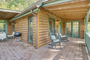 A log cabin with a porch, outdoor seating, and a barbecue grill. - Cabin w/ Hot Tub, Near Mercier Orchard & Downtown (Blue Ridge)