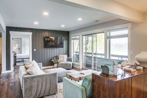 A modern living room with a grey sofa set, a wooden coffee table, and a flat-screen TV mounted on the wall.