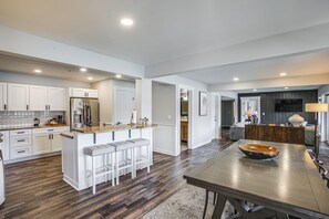 A modern kitchen with white cabinetry, a stainless steel refrigerator, and a wooden island with bar stools. - Dock Access, Deck & BBQ on Liberty Lake (Liberty Lake)