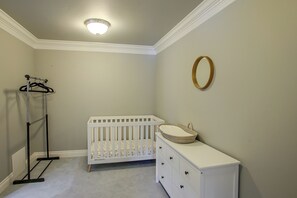 A room with a crib, dresser, and a coat rack. - Liberty Lake Retreat w/ Private Dock (Liberty Lake)