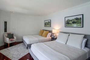 A hotel room with two beds, a sitting area with a chair, and two framed landscape paintings on the wall. - Liberty Lake Retreat w/ Private Dock (Liberty Lake)