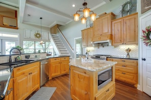 A kitchen with wooden cabinets, a granite countertop, a built-in oven, and a staircase leading to an upper level. - Fredericksburg House & Cabin 10 Mi to Main St (Fredericksburg)