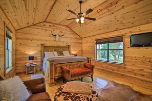 A log cabin bedroom with a bed, a chair, a television, and a ceiling fan. - Fredericksburg House & Cabin 10 Mi to Main St (Fredericksburg)