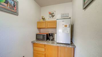 A compact kitchen with a microwave, toaster, and refrigerator.