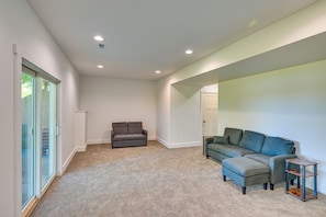 A spacious living area with a grey sofa, a smaller grey armchair, and a wooden side table. - Large Deck w/ Views! Brand New Three Rivers Home (Three Rivers)