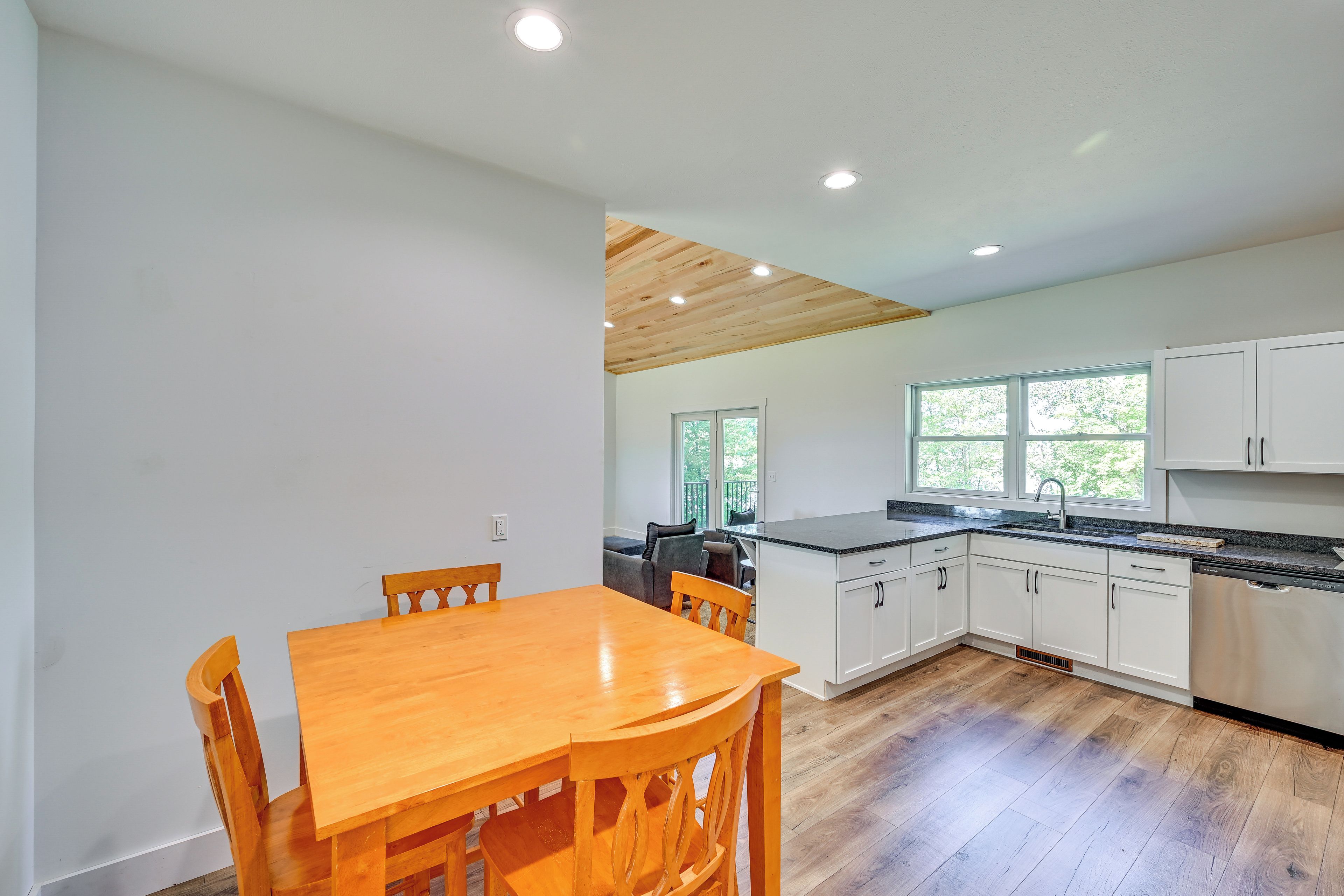 Una cocina moderna con armarios de madera, encimera de granito y lavavajillas integrado.