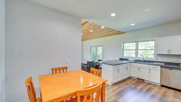Una cocina moderna con armarios de madera, encimera de granito y lavavajillas integrado.