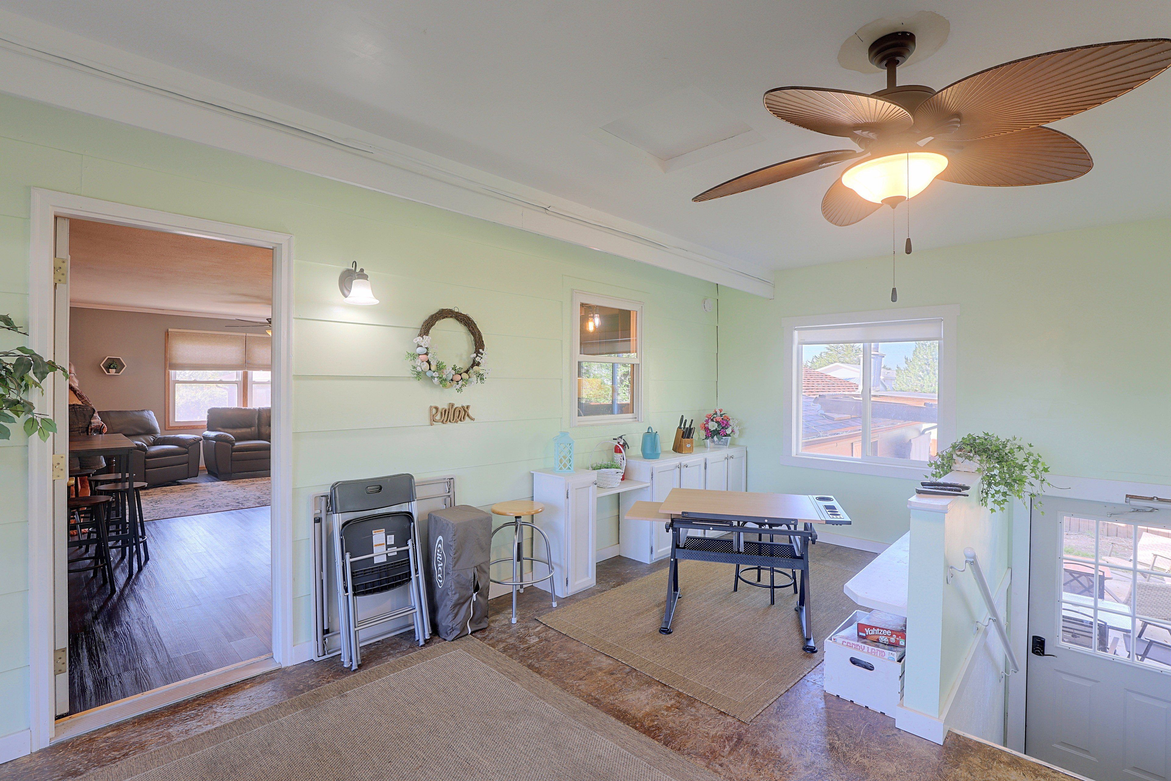 A spacious kitchen with a dining area, a ceiling fan, and a view of the outside.