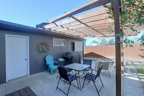 A patio with a table and chairs, a barbecue grill, and a welcome sign. - Private Hot Tub! Spacious Home in Rapid City (Rapid City)