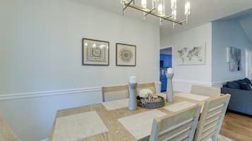 A dining area with a wooden table, chairs, a candle, and a welcome sign.
