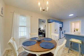 A dining area with a round table, chairs, and blue placemats.
