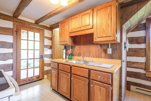 A kitchen with wooden cabinets, a sink, and a window. - Peaceful Farm House Near Catoctin Mtn Park (Myersville)