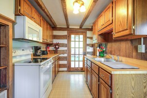 Una cocina con armarios de madera, un microondas, una cafetera y un lavabo.