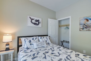 A bedroom with a bed, a nightstand, a lamp, a door, and a closet. - 2-unit Ocean Isle Beach Getaway Near Pier & Dining (Ocean Isle Beach)