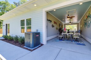 A house with a covered patio, an air conditioning unit, and a dining area with a table and chairs. - 2-unit Ocean Isle Beach Getaway Near Pier & Dining (Ocean Isle Beach)