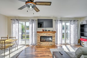 A spacious living area with a fireplace, a dining table, and a sofa. - Lakefront Escape in Vandalia: Ski, Fish & Stargaze (Vandalia)