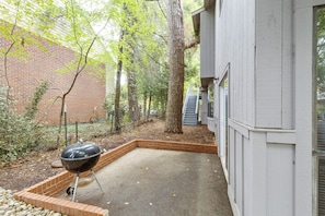 A backyard with a barbecue grill, a brick planter, and a white building. - Walk to the Stadium & Clemson: 3BR w/ Parking! (Clemson)