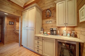A kitchen with wooden cabinets, a coffee station, and a view of the living area. - On-site Hiking! Spacious Happy Jack Home w/ Deck (Happy Jack)