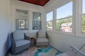A sunroom with wicker chairs, a small table, and a view of a red brick house. - 4 Mi to Dtwn & Bengals Games! Multi-level Charmer (Covington)