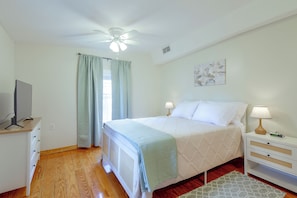 A bedroom with a bed, bedside lamps, a TV on a stand, a ceiling fan, and a window with curtains. - Beach Escape 1 Mi to Okaloosa Island & Dtwn (Fort Walton Beach)