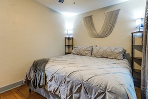 A bedroom with a bed, a hanging hammock, bedside lamps, and a wooden floor. - Dayton 2-unit Getaway Near UD & Oregon District (Dayton)