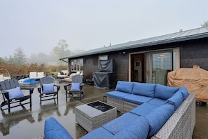 An outdoor patio with a sofa, chairs, and a covered grill area. - Waterfront Bellingham Home w/ Fire Pits & Patio (Bellingham)