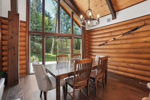 A log cabin interior with a dining table, chairs, and a chandelier. - Cabin & Guest House Near Sandy River Trails! (Brightwood)
