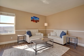A living room with two sofas, a coffee table, a floor lamp, and a painting on the wall. - Extended Mtn-view Stay w/ Hot Tub Near Skiing (Mountain Green)