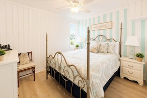 A bedroom with a four-poster bed, a nightstand, a chair, and a ceiling fan. - 'paradise Found' on Lake Louisa: Swim + Fish! (Clermont)