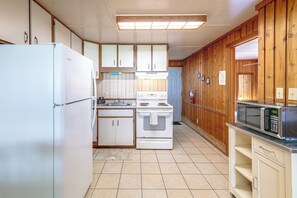 A compact kitchen with a refrigerator, stove, microwave, and wooden cabinets. - 'lake Life' Retreat in Clermont w/ Pool & Pier (Clermont)