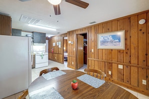 A dining area with a wooden table, chairs, and a ceiling fan. - Parrot Head Paradise: Lake Access & Pickleball (Clermont)