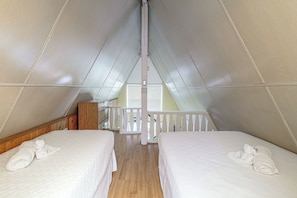 A room with two beds, wooden flooring, a white railing, and a window. - 'livin' on Sunshine' Lake Louisa Escape! (Clermont)