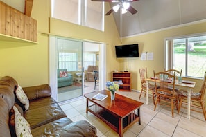 A spacious living area with a leather sofa, a wooden coffee table, and a dining table set with chairs. - 'livin' on Sunshine' Lake Louisa Escape! (Clermont)