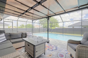 Eine überdachte Terrasse im Freien mit Pool, Sitzbereich und Tisch.