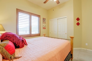 A bedroom with a bed, a window with blinds, a door, and a ceiling fan. - Desert Hills Fenced Acre! Pool, Spa + Dogs Allowed (Phoenix)