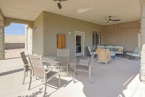A covered patio area with a glass table and chairs, a sofa, and a ceiling fan. - Mtn-view Couples Stay in Desert Hills Near Trails (Phoenix)