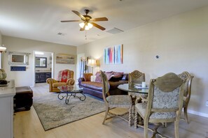 A spacious living area with a ceiling fan, a dining table with chairs, a sofa, and a coffee table. - Mtn-view Couples Stay in Desert Hills Near Trails (Phoenix)