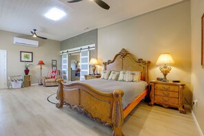 A spacious bedroom with a large bed, two bedside tables, a wardrobe, a chair, and a ceiling fan. - Mtn-view Couples Stay in Desert Hills Near Trails (Phoenix)