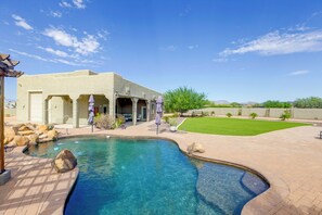 A pool area with a clear blue pool, a patio, and a building with outdoor seating. - Mtn-view Couples Stay in Desert Hills Near Trails (Phoenix)