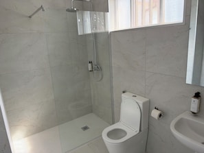 Un baño con ducha, inodoro y lavamanos.