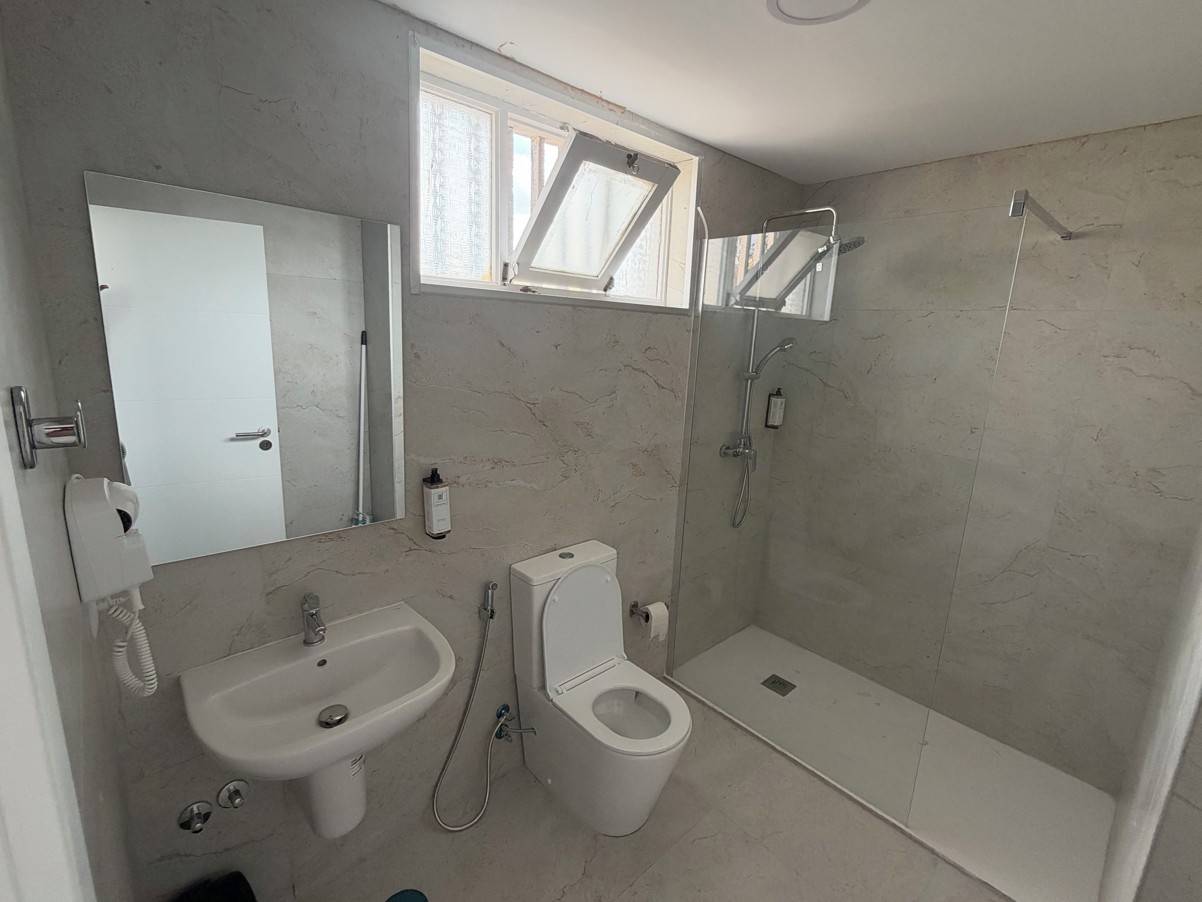 Un baño con lavamanos, inodoro y ducha.