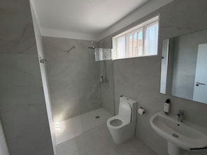 A bathroom with a toilet, a sink, and a shower. - Alojamento Local Cova Da Serpe (Figueira da Foz)