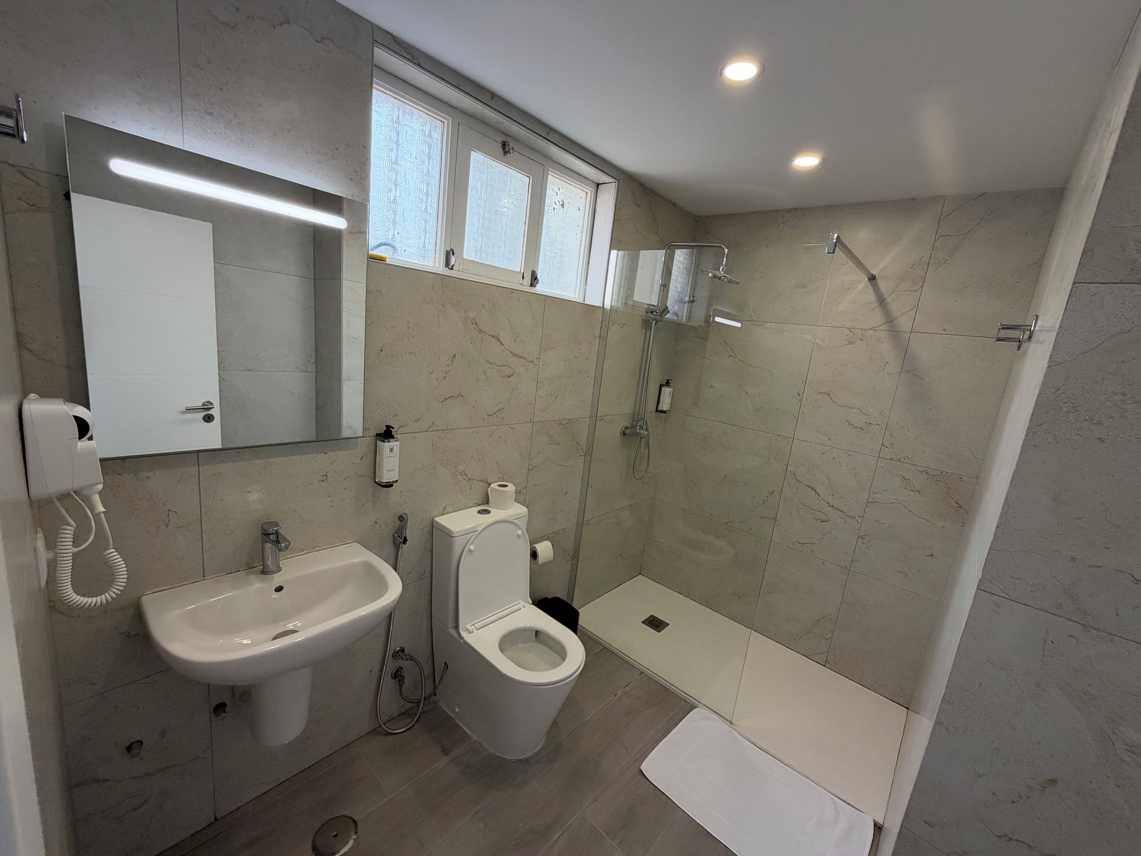 A modern bathroom with a sink, toilet, and shower.