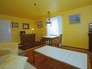 A room with a bed, a desk, a chair, a lamp, and a window with curtains. - Holiday Apartment With 1 Bedroom (Witsum)
