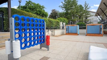 An outdoor seating area with a blue and white patterned partition, a white bench, and a blue and white striped structure.